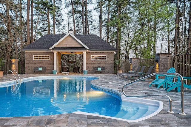 view of pool with fence, a fenced in pool, an outdoor structure, and an exterior structure