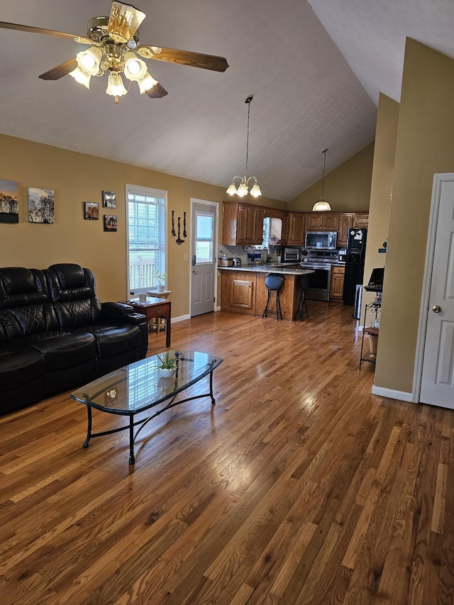 living room featuring lofted ceiling, a ceiling fan, and dark wood-style flooring