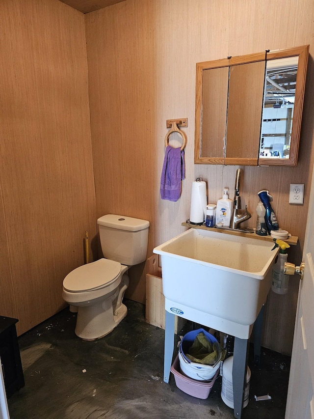 bathroom with wooden walls and toilet