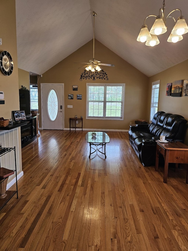 living room with baseboards, a ceiling fan, wood finished floors, and vaulted ceiling