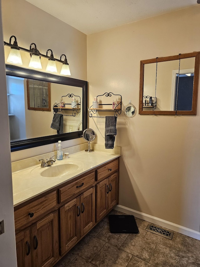 bathroom featuring baseboards, vanity, and visible vents