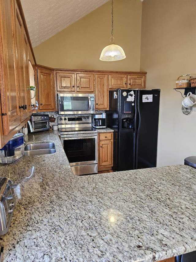 kitchen with light stone counters, brown cabinetry, and stainless steel appliances
