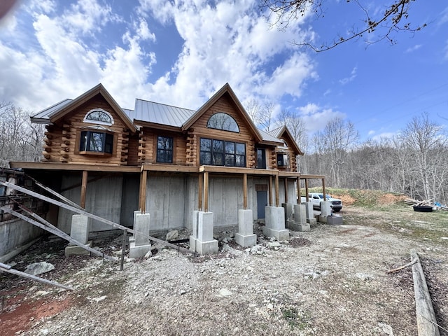 rear view of property with log exterior and metal roof