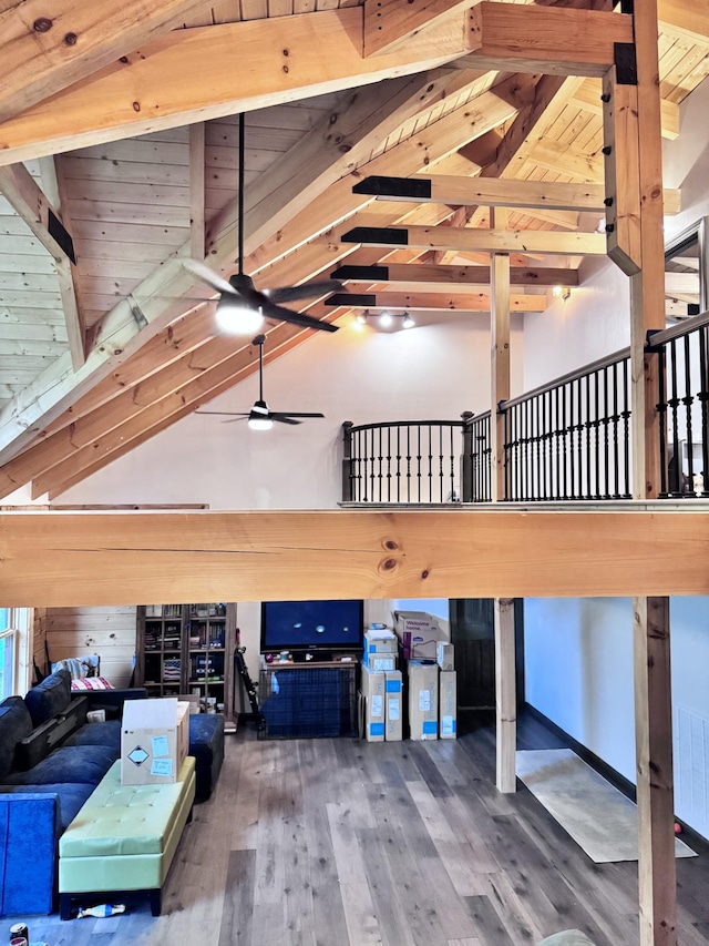 interior space featuring high vaulted ceiling, a ceiling fan, wood finished floors, beamed ceiling, and wooden ceiling