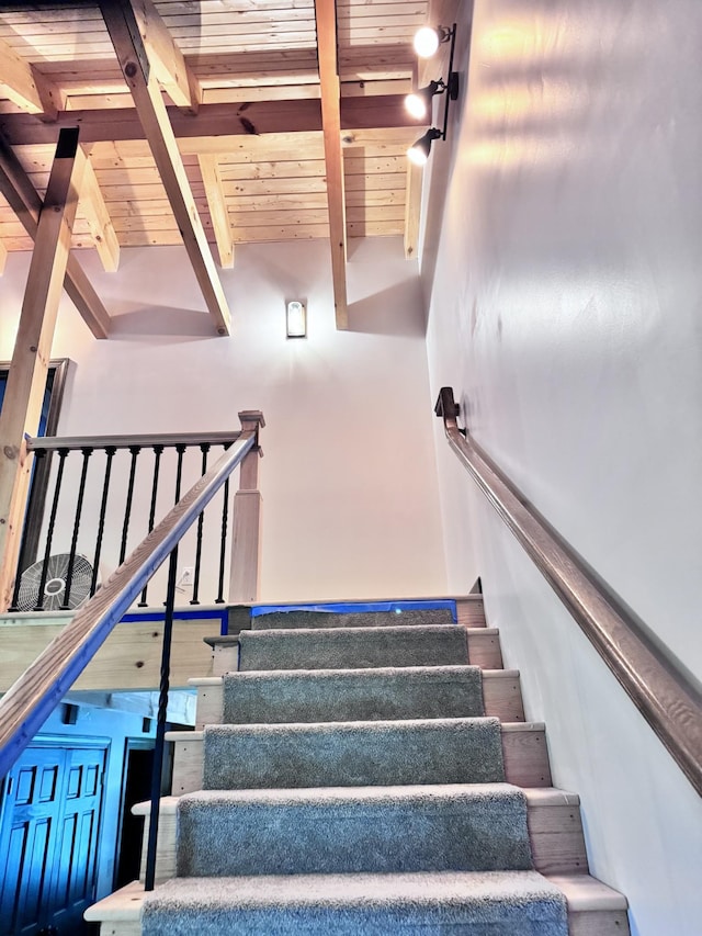 stairway with wood ceiling and beamed ceiling