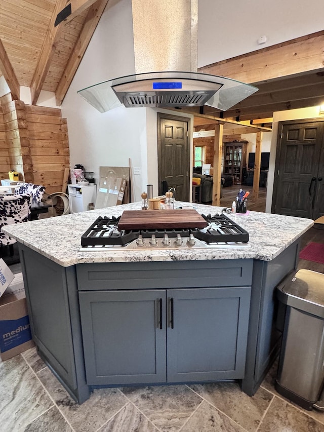 kitchen with gray cabinets, a center island, and light stone counters