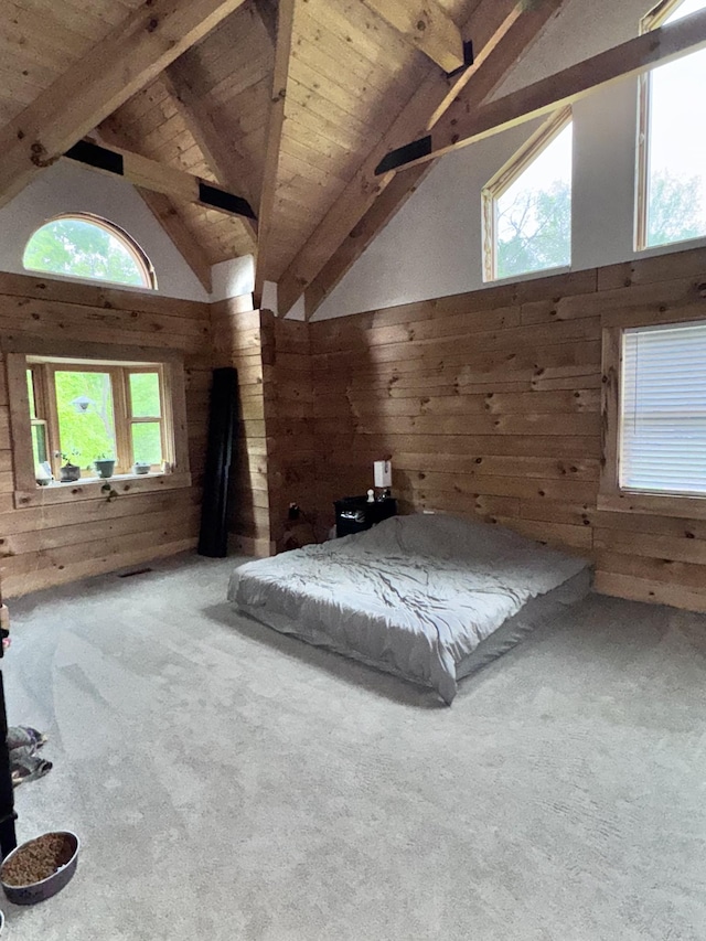 carpeted bedroom with wood ceiling, beamed ceiling, wooden walls, and high vaulted ceiling