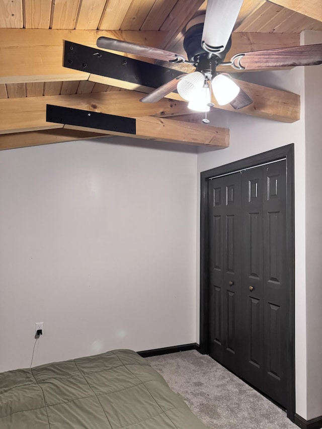 carpeted bedroom with wood ceiling, baseboards, a closet, and ceiling fan