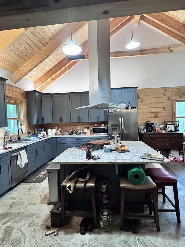 kitchen with a breakfast bar area, wooden ceiling, beam ceiling, and appliances with stainless steel finishes