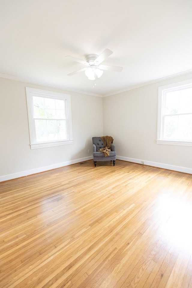 unfurnished room with crown molding, a ceiling fan, baseboards, and light wood-style flooring