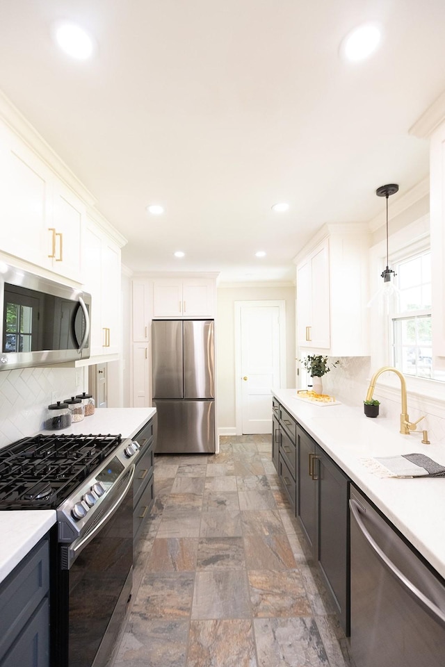 kitchen featuring light countertops, appliances with stainless steel finishes, backsplash, and white cabinetry