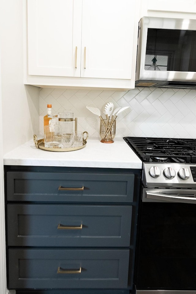 kitchen with light countertops, tasteful backsplash, white cabinets, and stainless steel appliances