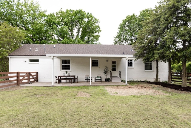 rear view of property with a patio, a fenced backyard, and a yard
