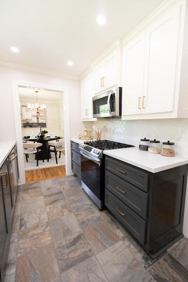 kitchen with white cabinetry, appliances with stainless steel finishes, a chandelier, and tasteful backsplash