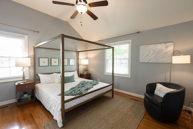 bedroom with baseboards, visible vents, wood finished floors, and lofted ceiling