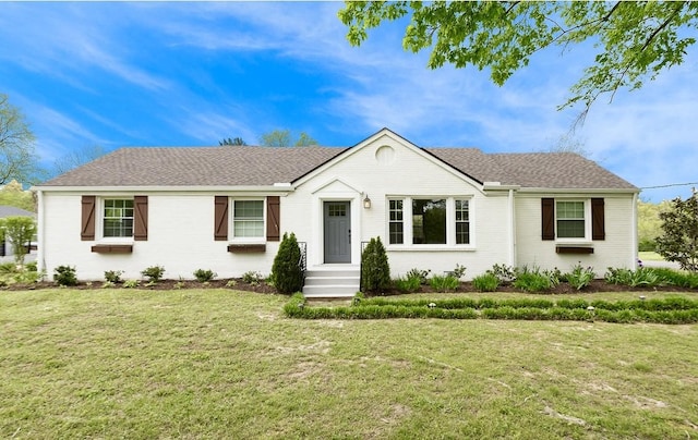 single story home featuring brick siding, roof with shingles, and a front yard