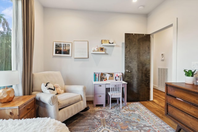 bedroom with baseboards, wood finished floors, and visible vents
