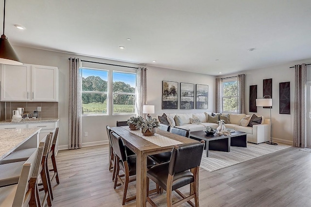 dining room with recessed lighting, light wood-style floors, and baseboards