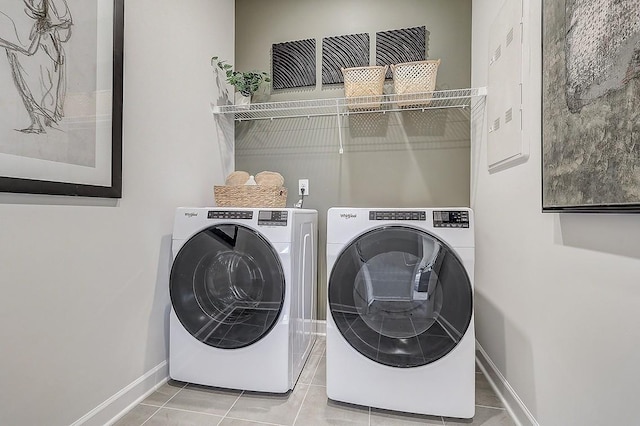 clothes washing area with washing machine and clothes dryer, tile patterned floors, baseboards, and laundry area