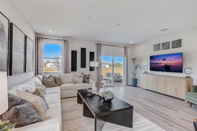 living room with recessed lighting, light wood-style floors, visible vents, and a healthy amount of sunlight