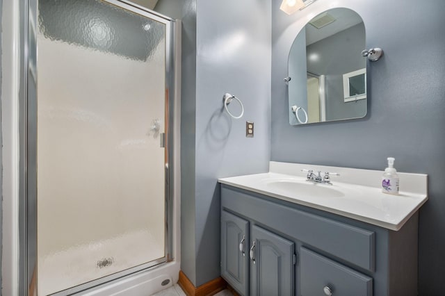 full bath featuring vanity, a stall shower, and visible vents