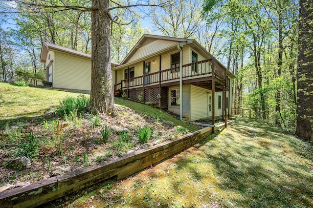 rear view of property featuring a wooden deck and a yard
