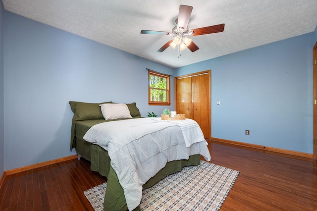bedroom featuring a textured ceiling, wood finished floors, a closet, and baseboards