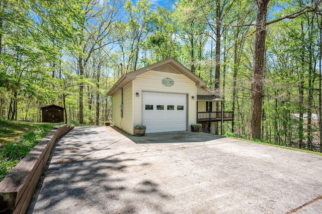 garage with concrete driveway and a shed