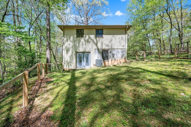back of property featuring a fenced backyard, a yard, and cooling unit