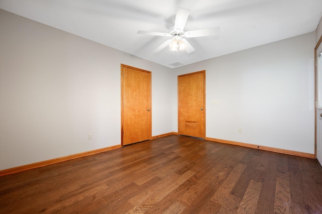 unfurnished room featuring visible vents, wood finished floors, baseboards, and ceiling fan
