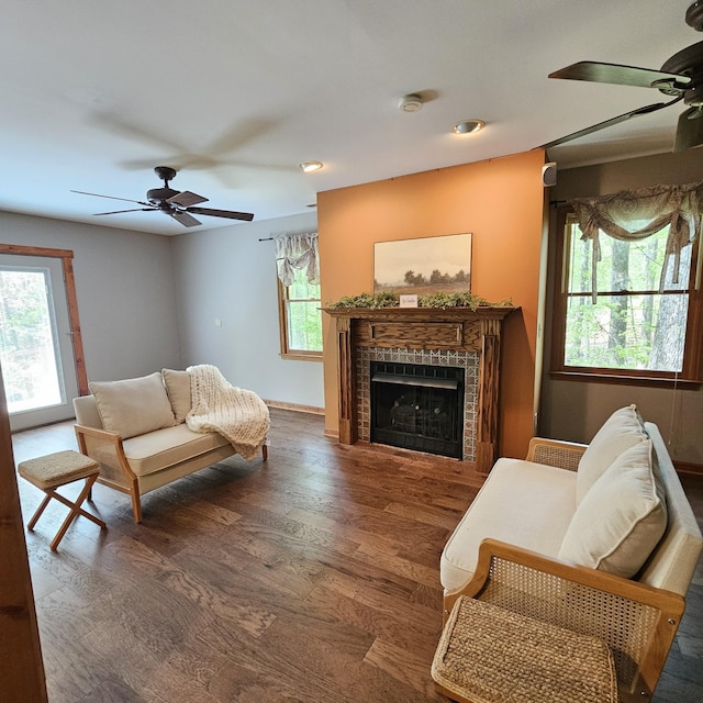 living room with baseboards, wood finished floors, a fireplace, and ceiling fan