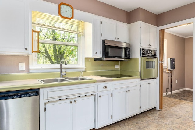 kitchen featuring white cabinets, appliances with stainless steel finishes, a sink, and light countertops