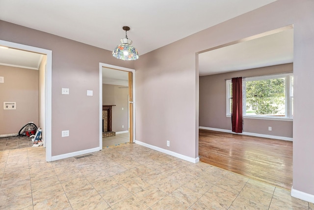 empty room with baseboards, a brick fireplace, and visible vents