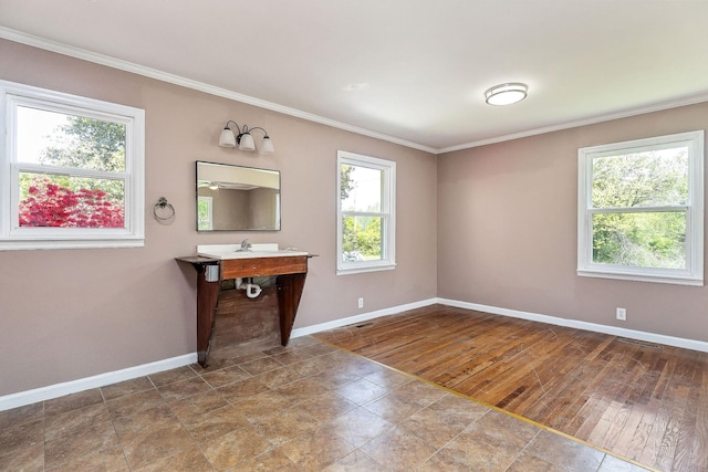 interior space with baseboards, crown molding, and wood finished floors