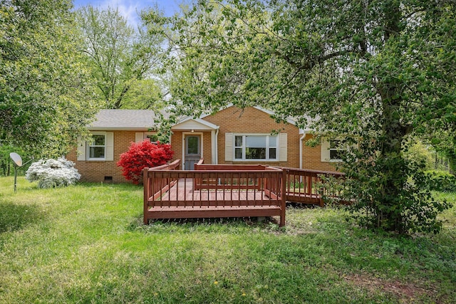 rear view of property featuring brick siding, a wooden deck, crawl space, and a yard