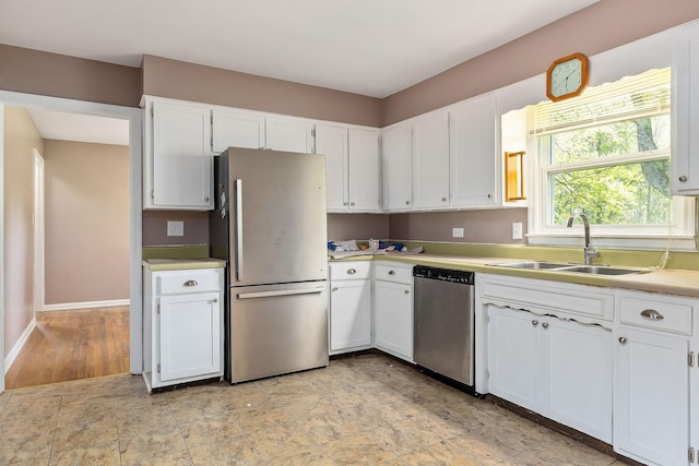 kitchen featuring white cabinets, appliances with stainless steel finishes, and a sink