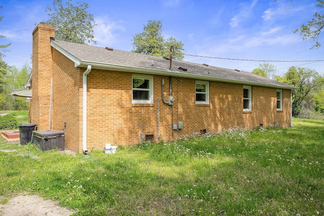 back of house with a chimney, brick siding, roof with shingles, and crawl space