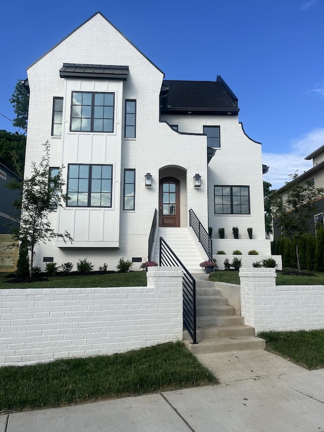 view of front of house featuring board and batten siding and brick siding