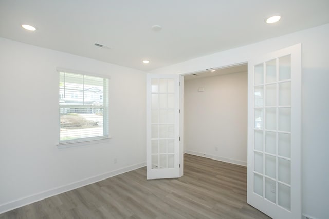 unfurnished room featuring wood finished floors, french doors, baseboards, and recessed lighting