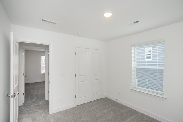 unfurnished bedroom featuring visible vents, baseboards, and carpet floors
