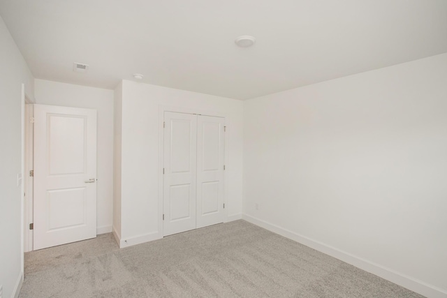 unfurnished bedroom featuring carpet, a closet, baseboards, and visible vents