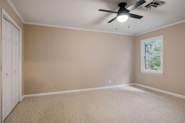 unfurnished bedroom with baseboards, visible vents, light colored carpet, and ornamental molding