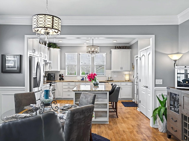 kitchen with light stone counters, white cabinets, open shelves, and stainless steel appliances