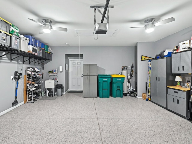 garage featuring ceiling fan, a garage door opener, and baseboards