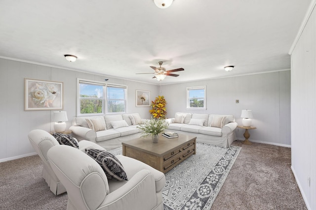 carpeted living area featuring baseboards, ceiling fan, a healthy amount of sunlight, and crown molding