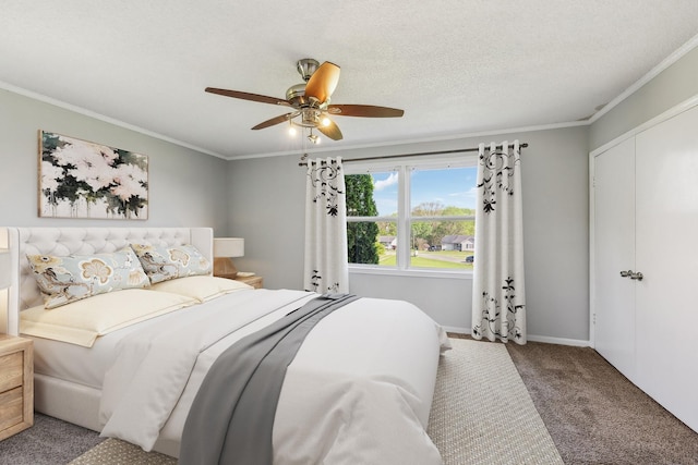 carpeted bedroom with ceiling fan, baseboards, ornamental molding, and a closet