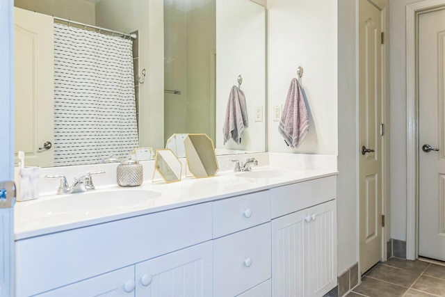 bathroom with a shower with shower curtain, double vanity, and a sink