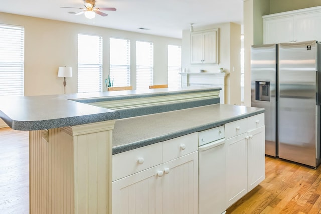 kitchen with dark countertops, light wood-style floors, ceiling fan, stainless steel fridge with ice dispenser, and white cabinets