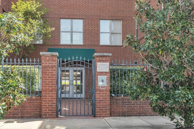 view of gate featuring french doors and a fenced front yard