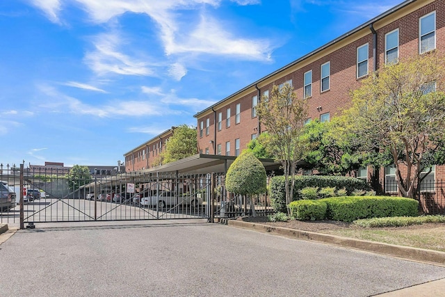 view of street with a gate, a gated entry, and curbs